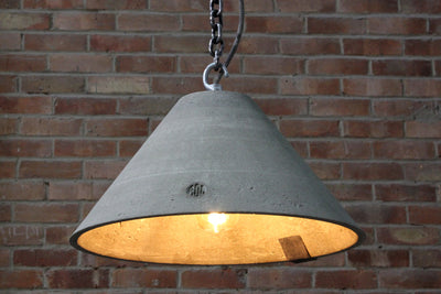 Our Luster Natural 1 smoothed artisan concrete pendant light showing chain hook and concrete surface detail,  the counter balance lead weight, chain and electrical cable