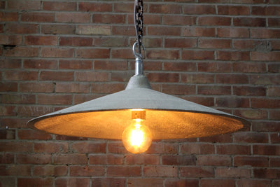 Our Vivid Natural 1 raw surface artisan concrete pendant light showing chain hook and concrete surface detail, chain and electrical cable. Also showing the bulb and the inside surface detail of the lampshade