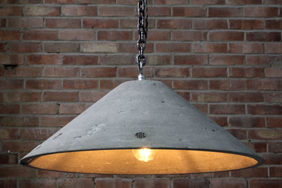 Our Lustrous Natural 1 smoothed artisan concrete pendant light showing chain hook and concrete surface detail,  the counter balance lead weight, chain and electrical cable. Also showing the ROC embossed logo on the concrete lampshade 