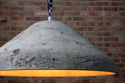 Raw artisan concrete pendant light showing chain hook and concrete surface detail